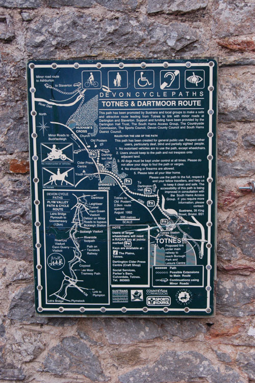 A map mounted on a stone wall shows the route from Totnes to Dartington.